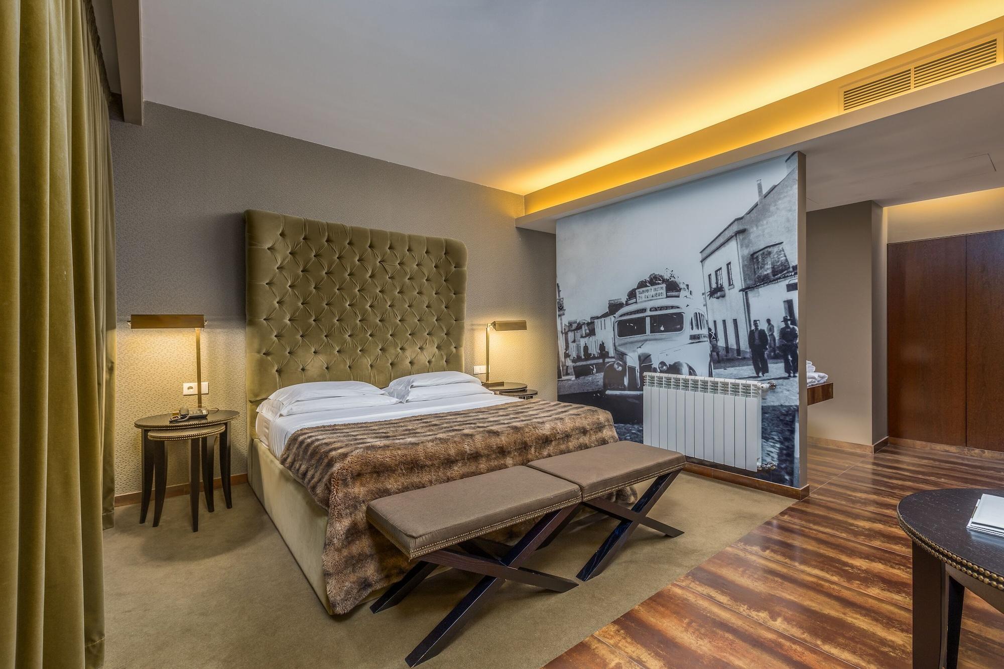 Ap Lago Montargil - Conference & Spa Zewnętrze zdjęcie The photo shows a modern hotel room featuring a king-sized bed with a tufted headboard, dressed in white linens and a decorative throw blanket. On either side of the bed, there are bedside tables with lamps. The room is well-lit, with an ambient ceil